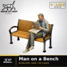 0 (1,43.5) - Homme lisant le journal sur un banc